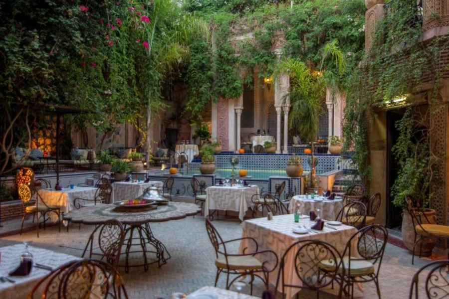 Riad Palais Sebban Marrakech Courtyard of Riad Palais Sebban with hanging plants and tables set up in this pretty riad